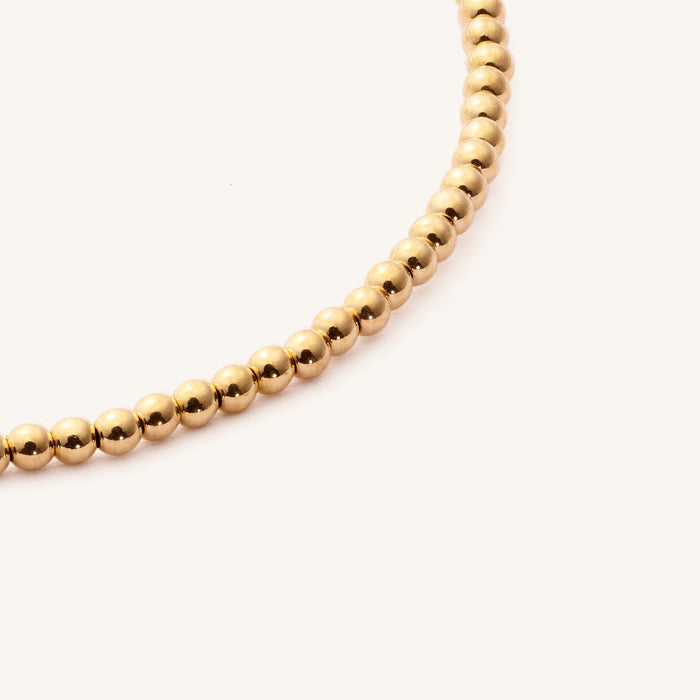 Close up of a gold mini bead bracelet