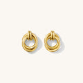 Close-up shot of gold circular knot studs on a white background