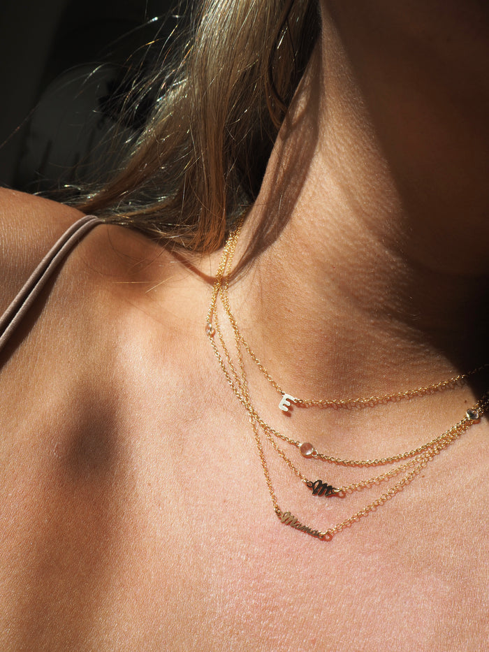 Close up of a neckline wearing the 14k gold fill mini mama necklace