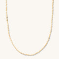 Close up of the gold Mini Pearl necklace on a white background