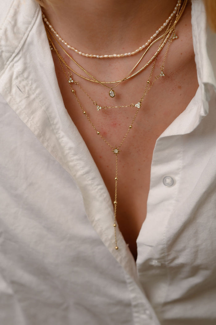 The gold Mini Pearl necklace from Beads by Tara, shown on a white background