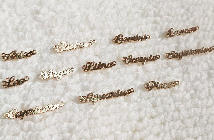 Close up of a neckline wearing the mini zodiac necklace layered with gold chains