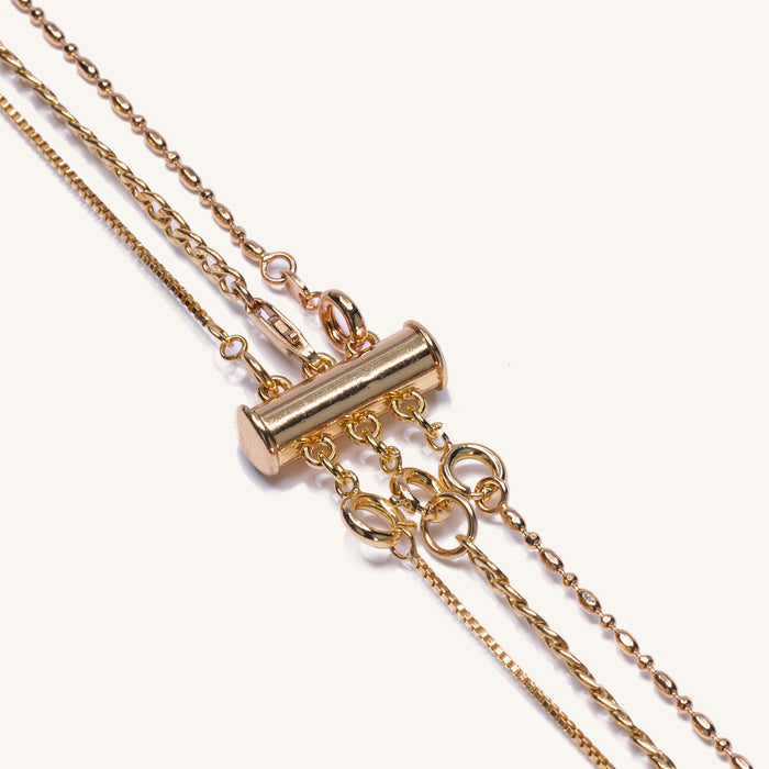 Close up of a neckline wearing layered chains held apart by the necklace detangler