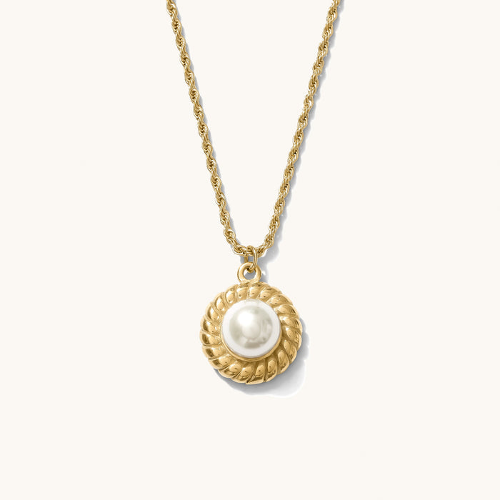 Close up of the gold La Mer pearl pendant necklace on a white background