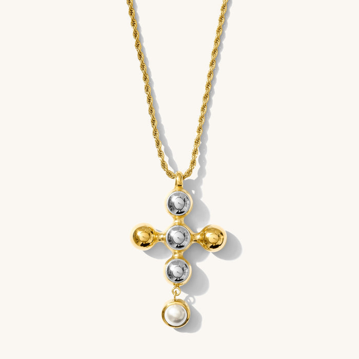 Close up of the gold Jordan cross pendant necklace on a white background