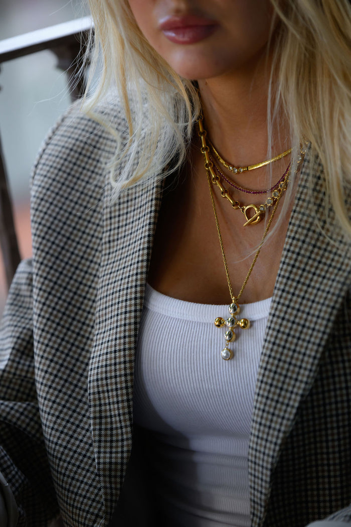 The gold Jordan necklace mixing silver and gold beads with a bold cross pendant