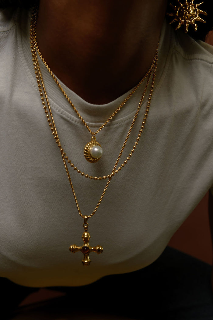 Close view of the gold La Mer pearl pendant necklace on a white background