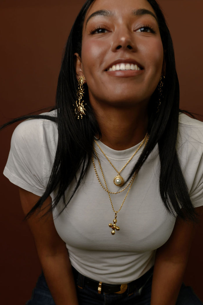 The gold La Mer pearl pendant necklace photographed on a white background