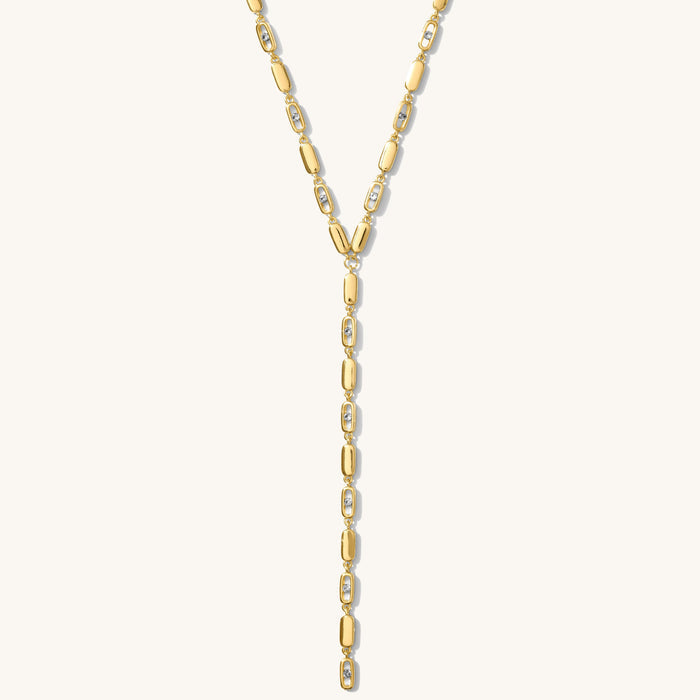 Close up of the gold Nellie lariat necklace on a white background