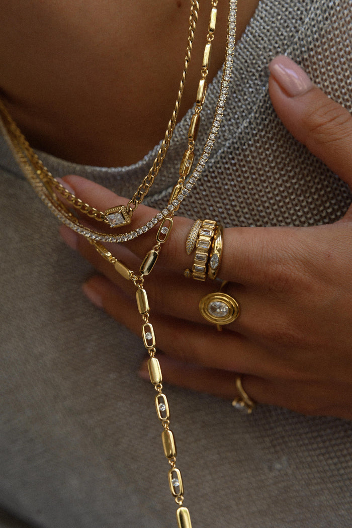 Bold gold plated lariat necklace designed to elongate the neckline
