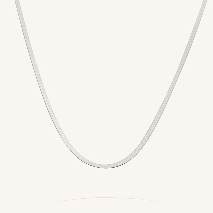 Close up of the silver Nile herringbone chain necklace on a white background