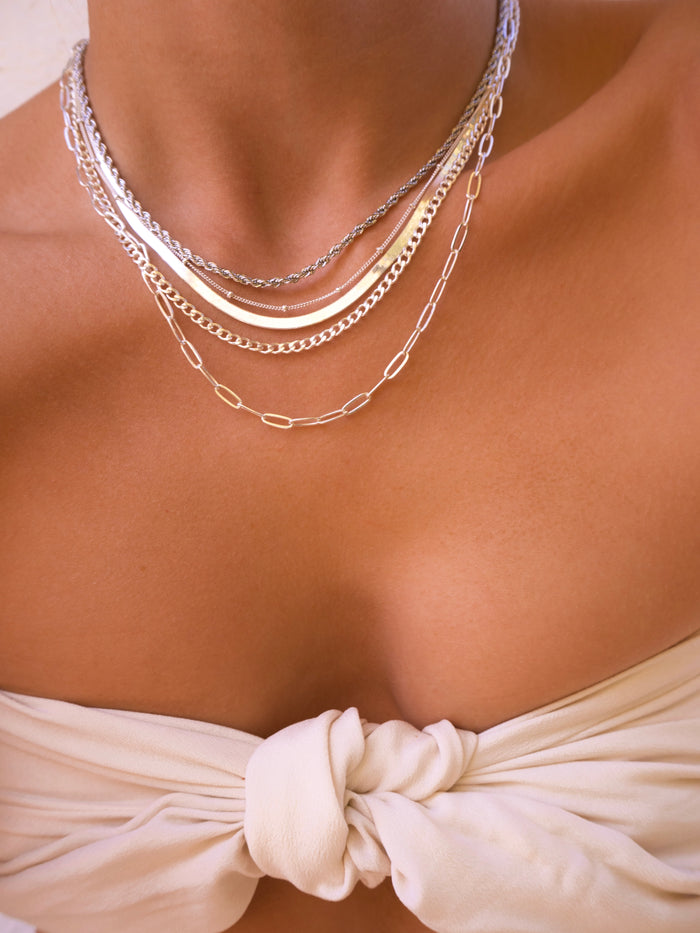 Silver Nile herringbone necklace worn layered with dainty chains