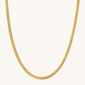 Close up of the gold Nile herringbone chain necklace on a white background