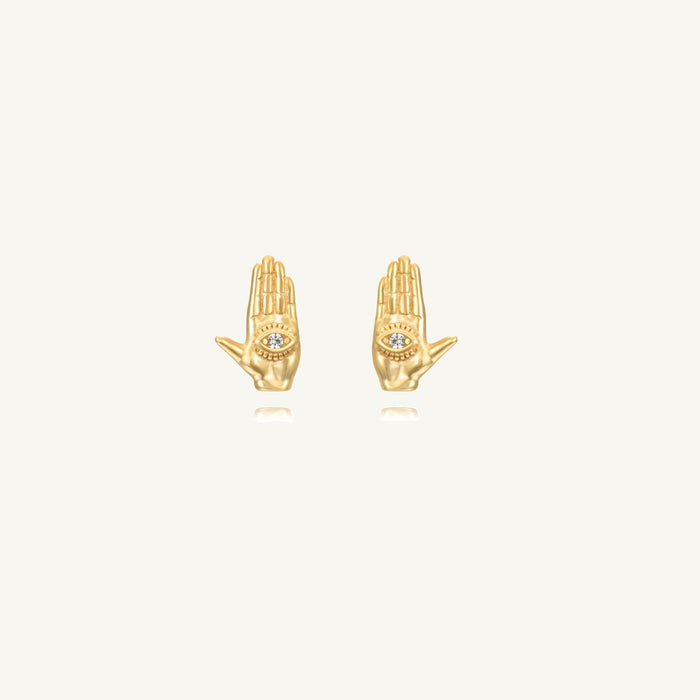 Close up of gold studs with eye symbol on a white background