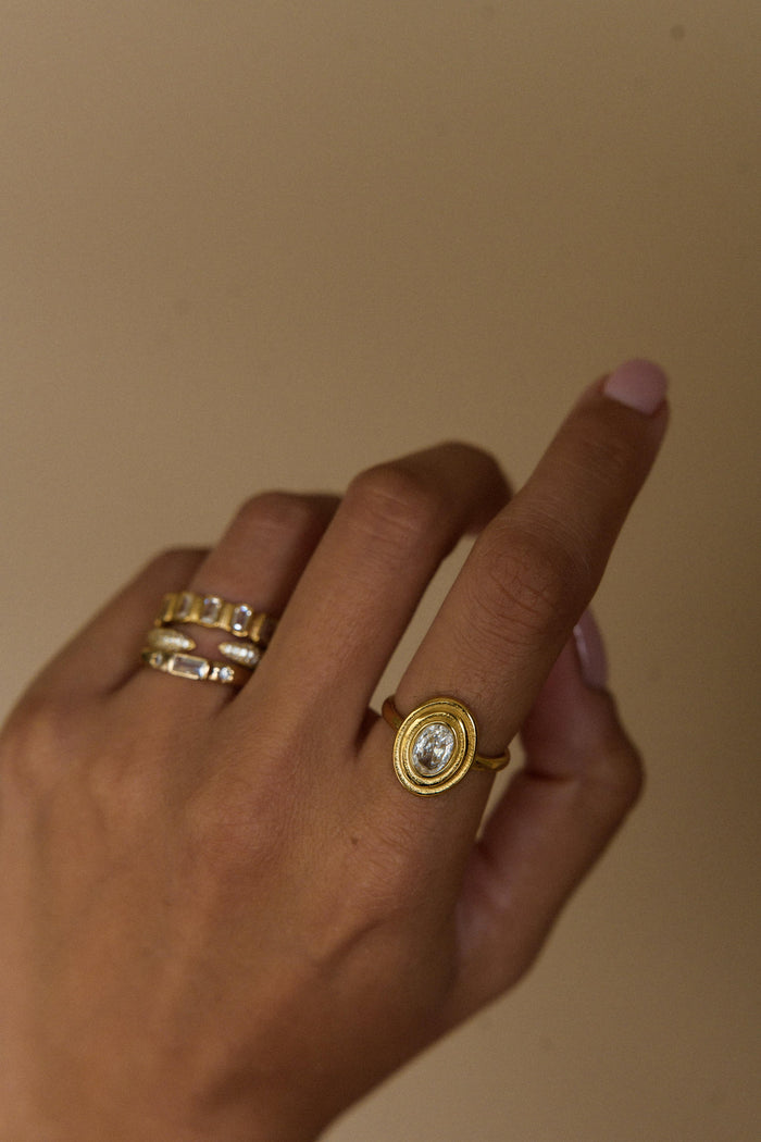 Oval cubic zirconia framed by a bold layered gold bezel setting