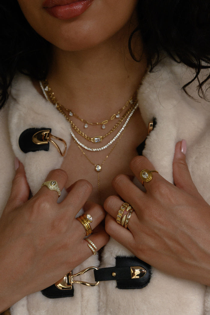 Sculptural gold ring with a layered bezel around an oval stone