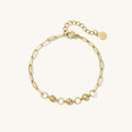 Close up of gold chain bracelet with stones on a white background