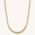 Close up of the gold Ombre bead necklace on a white background
