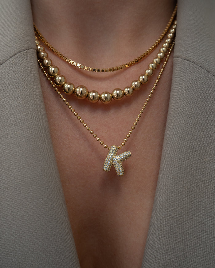 A model wearing the gold Ombre bead necklace in a Beads by Tara campaign image