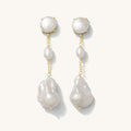 Close up of pearl dangle earrings on a white background