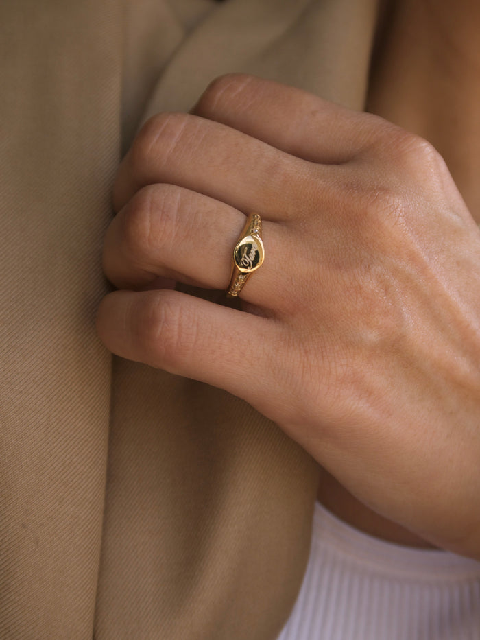 Oval signet ring in gold with a personalized engraving and crystal frame