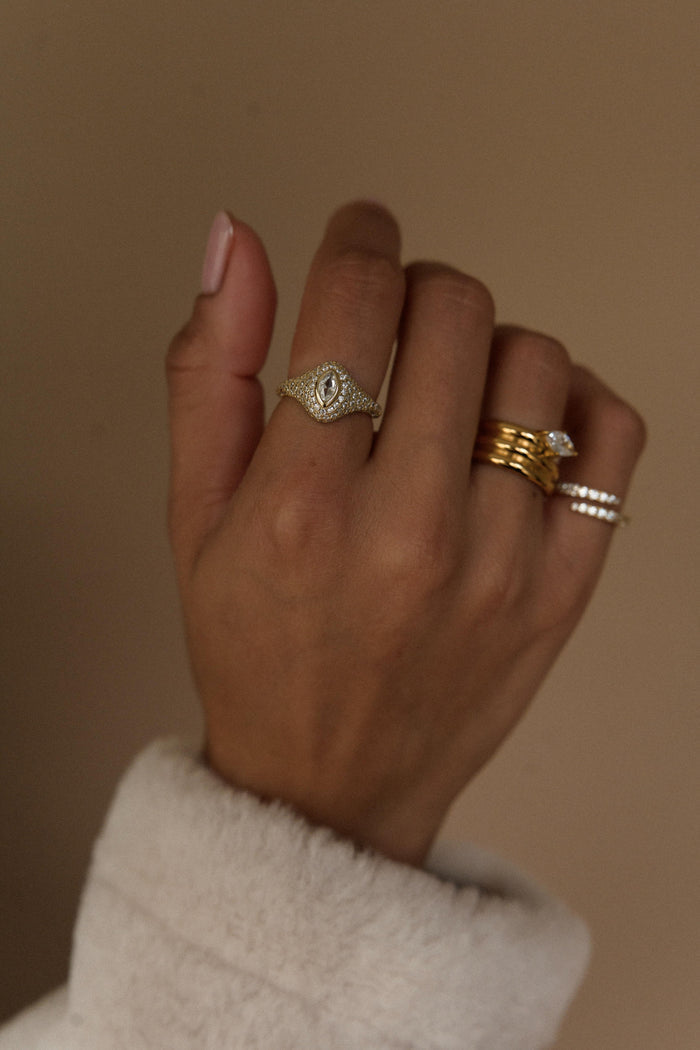 Gold signet ring with a marquise cut center framed by tiny pave stones