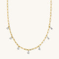 Close up of the gold Pear Drop necklace on a white background
