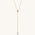 Close up of the gold Pear Lariat necklace on a white background