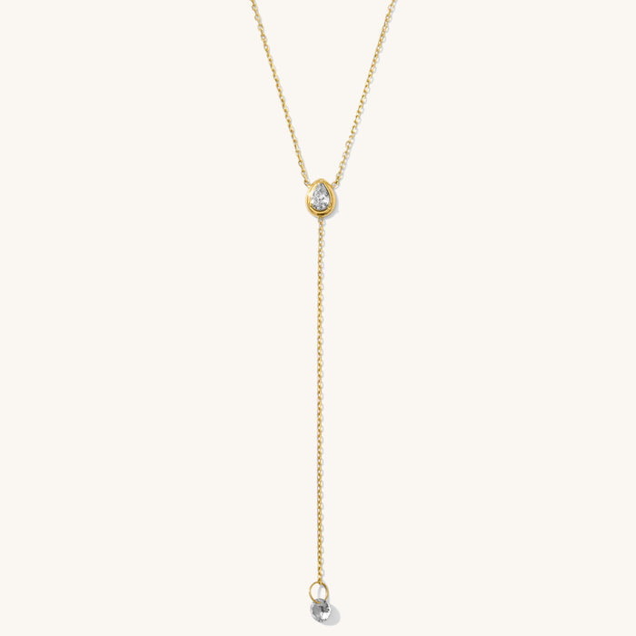 Close up of the gold Pear Lariat necklace on a white background