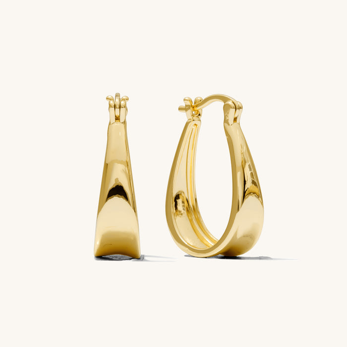 Close up of gold hoop earrings on a white background