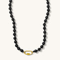 Close up of the Porto necklace in glossy obsidian black beads on a white background