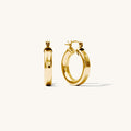 Close up of chunky gold hoop earrings on a white background