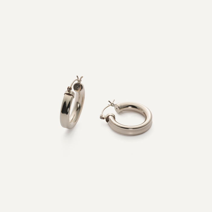 Close up of silver chunky hoop earrings on a white background
