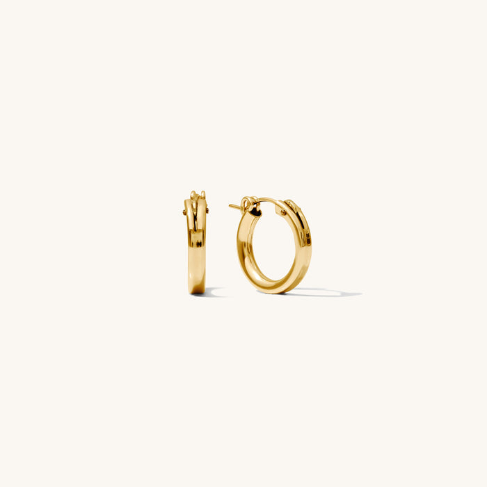 Close up of gold hoop earrings on a white background