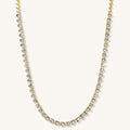 Close up of the gold Queen of Hearts bezel tennis necklace on a white background