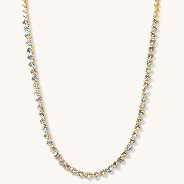 Close up of the gold Queen of Hearts bezel tennis necklace on a white background