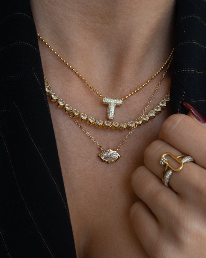 Campaign shot of a model wearing the gold Queen of Hearts bezel tennis necklace