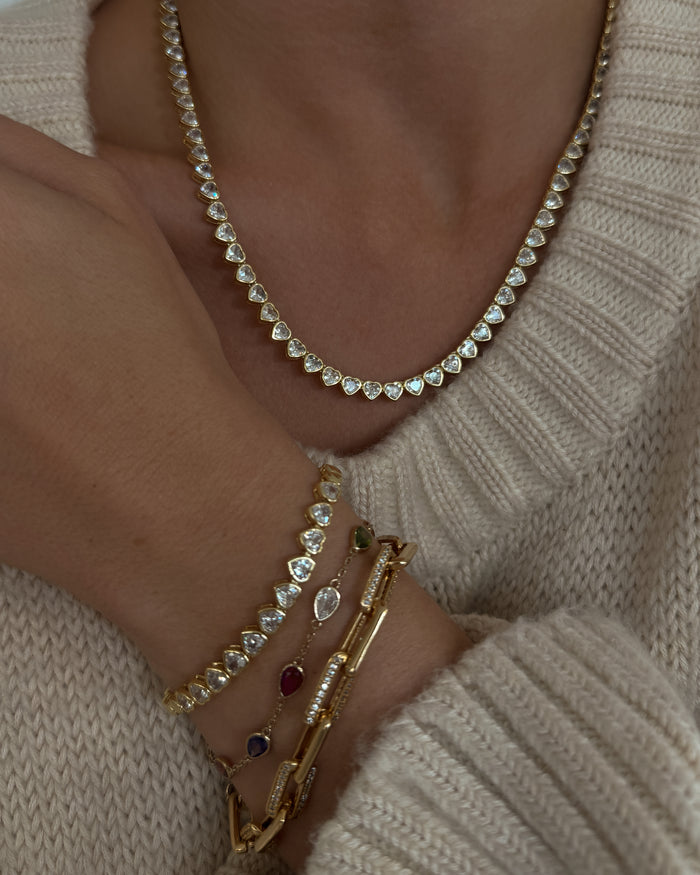 A model wearing the gold Queen of Hearts bezel tennis necklace in a Beads by Tara campaign image