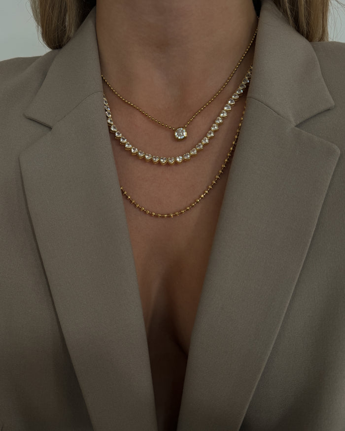 Model styled in the gold Queen of Hearts bezel tennis necklace
