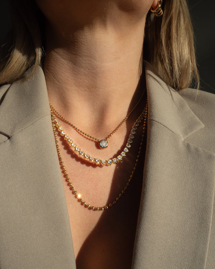 Model wearing the gold Queen of Hearts bezel tennis necklace, photographed for Beads by Tara