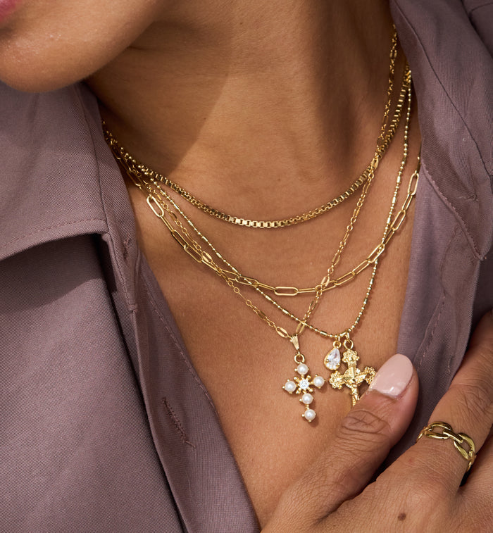 The Queen's Cross necklace, a classically feminine pearl and gold design