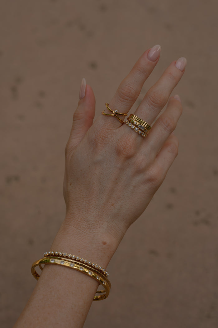 Close view of the gold Raeé fluted ring on a white background