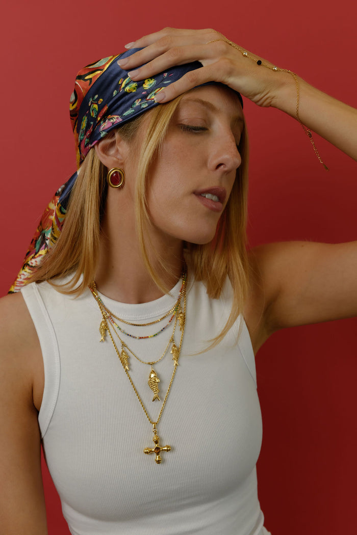 Detail view of the gold Rainbow Pearl necklace on a white background