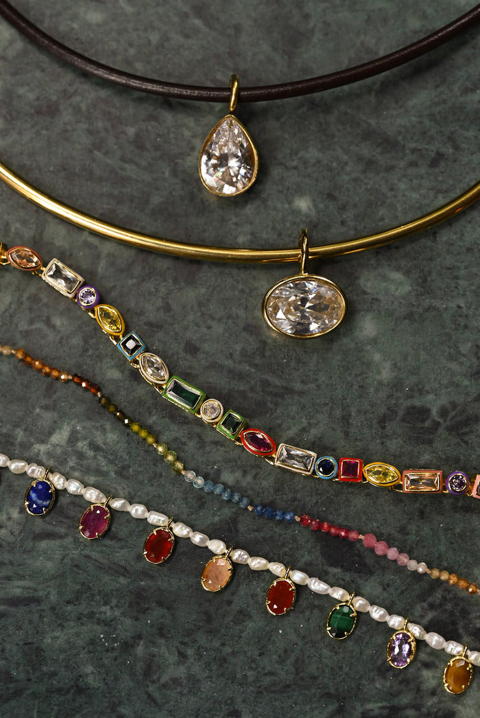 Collection of necklaces with various pendants on a dark surface