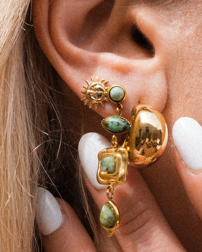 Close-up of an ear with multiple gold earrings
