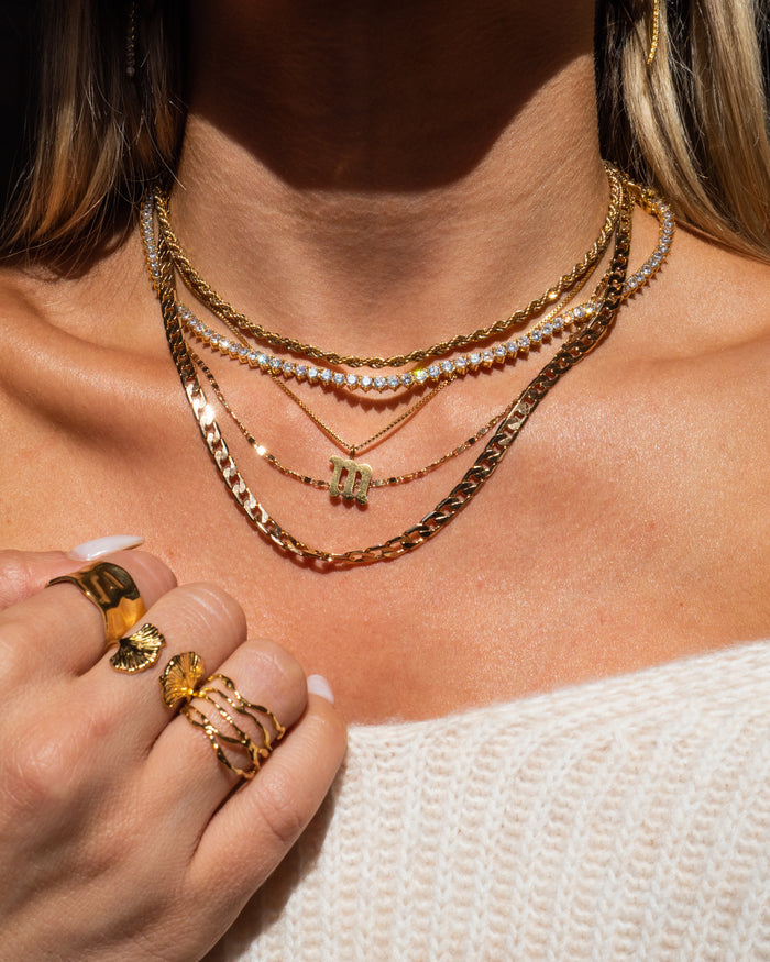 Model wearing the Rio rope chain layered into a gold necklace stack