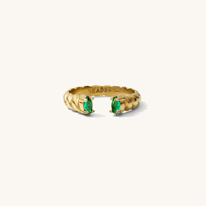 Roman ring in emerald, an open cuff band with green stones framing the opening
