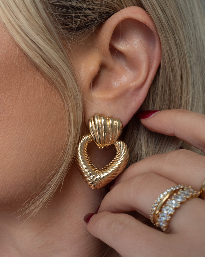 Close up of an ear with a statement heart earring