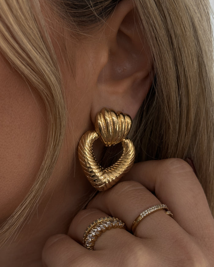 Close up of an ear with a statement heart earring