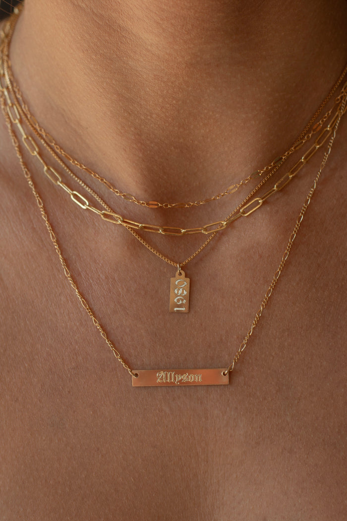 Rosie necklace with a small polished tag that catches the light